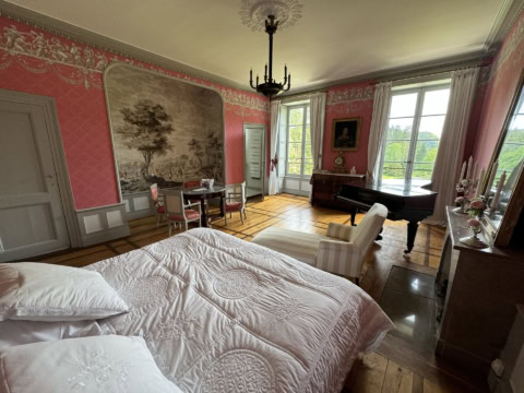 josephine Elegantes Zimmer in La Villa Palladienne au Château des Yams, mit Vintage-Möbeln, Klavier und klassischer Dekoration, die einen luxuriösen und historischen Rahmen bietet.